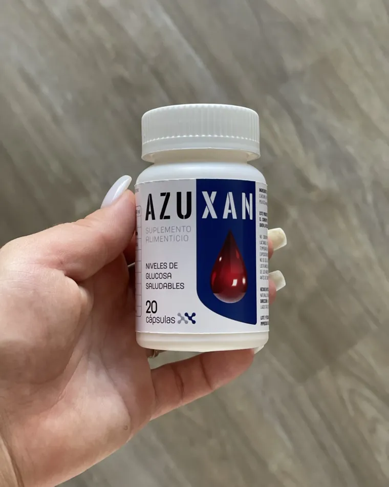 Mano sosteniendo un frasco de AZUXAN, suplemento alimenticio, 20 cápsulas